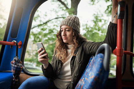Woman on bus looking at mobile phone
